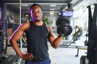 Motive olmuş Afro-Amerikan vücut geliştirici modern spor salonunda kol ve sırt kasları ile.