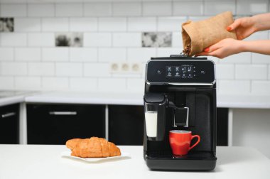 Mutfak ve kahve makinesinin bulanık arkaplanı senin için kırmızı bardak ve boşluk..