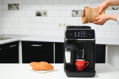 Mutfakta kahve fincanı olan bir kahve makinesi..