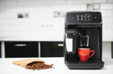Modern espresso coffee machine with a cup in kitchen.