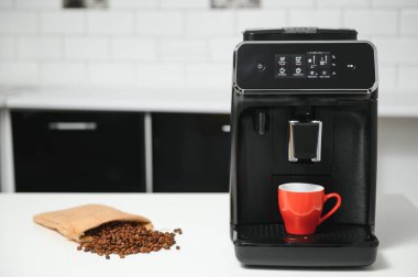 Mutfakta kahve fincanı olan bir kahve makinesi..