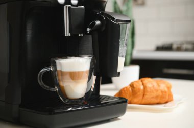 Kapuçino Kupası ile ev profesyonel kahve makinesi. kahve makinesi latte macchiato kapuçino süt köpüğü hazırlamak kavramı.