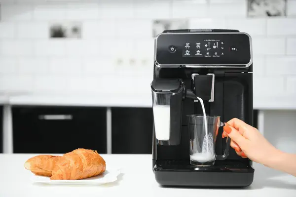 Modern coffee machine on table in kitchen.