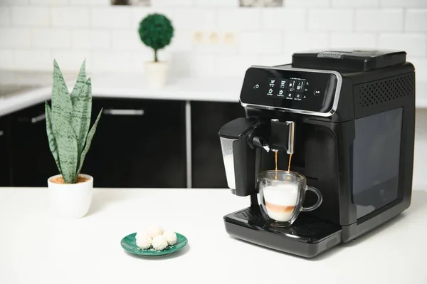 Modern coffee machine on table in kitchen.
