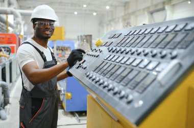 Plastik pencere çerçevesi fabrikasında çalışan Afro-Amerikalı bir erkek işçi..