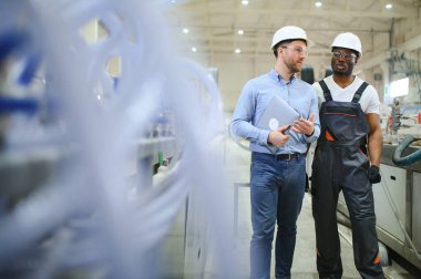 Bir mühendis üretim hattındaki bir işçiyle iletişim kurar..