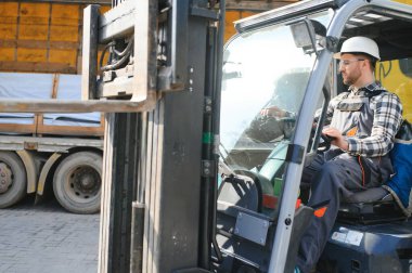 Forklift sürücüsünde çalışan adam fabrika lojistik gemisinde çalışmaktan memnun..
