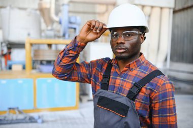 Fabrikada sanayi işçisi. Beyaz şapkalı genç teknisyen..