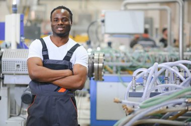 Plastik pencere çerçevesi fabrikasında çalışan Afro-Amerikalı bir erkek işçi..