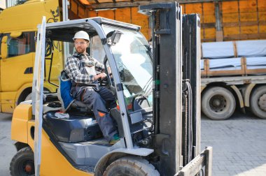 Forklift sürücüsünde çalışan adam fabrika lojistik gemisinde çalışmaktan memnun..