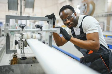 Alüminyum, PVC pencere ve kapı üretim fabrikası. PVC pencere ve kapılarını birleştiren el işçisi.