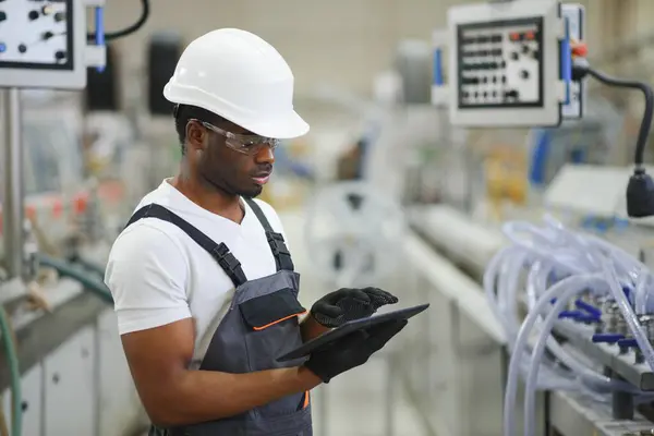 Professional Heavy Industry Engineer Worker Wearing Uniform, Glasses and Hard Hat in a Factory.