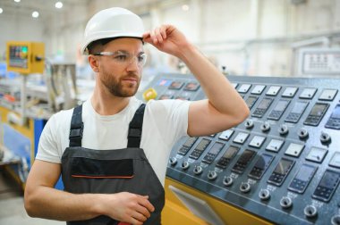 Özel üniformalı ve beyaz kasklı bir erkek işçi. PVC pencereleri için çerçeve üretimi.