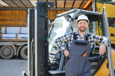 Forklift sürücüsünde çalışan adam fabrika lojistik gemisinde çalışmaktan memnun..