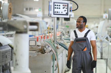 Plastik pencere çerçevesi fabrikasında çalışan Afro-Amerikalı bir erkek işçi..