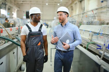 Bir mühendis üretim hattındaki bir işçiyle iletişim kurar..