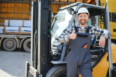 Fabrika deposundaki profesyonel forklift sürücüsünün portresi..
