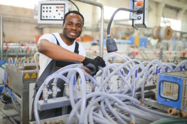 Plastik pencere çerçevesi fabrikasında çalışan Afro-Amerikalı bir erkek işçi..