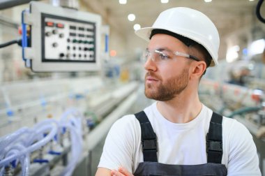 Plastik pencere ve kapı fabrikasında çalışan yakışıklı bir işçi..