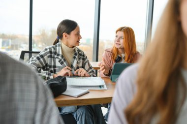 Öğrenciler sınıfta oturuyor, çalışıyor, tartışıyorlar..