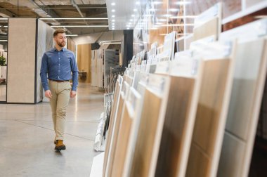 Adam ev banyosu için seramik fayans ve kap kacak seçiyor..