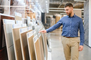 Markette fayans seçen genç bir adam.