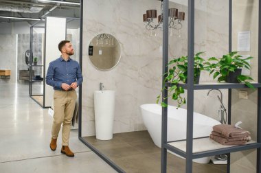 Banyo seçiyorum. Ev için malzeme deposunda bir adam..