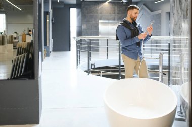 Genç adam banyo ve lavabo seçiyor..