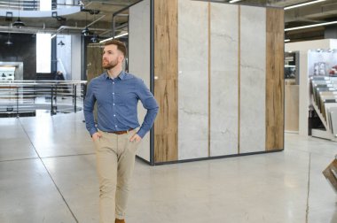 Markette fayans seçen genç bir adam.