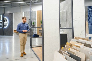 Markette fayans seçen genç bir adam.