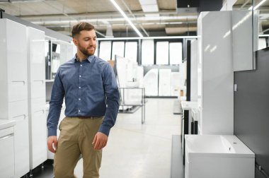 Bir sürü hijyenik eşyası olan yeni tuvalet mobilyalarını seçen bir adam..