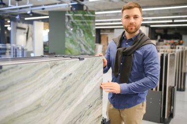 Markette fayans seçen genç bir adam.