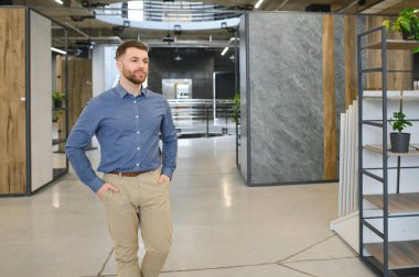 Orta yaşlı bir adam ev banyosu için seramik fayans ve kap kacak seçiyor..