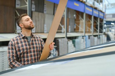 Hırdavatçıda döşemeyi seçen adam.