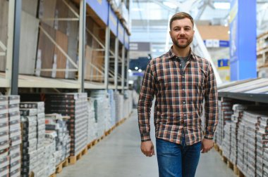 Hırdavatçıda döşemeyi seçen adam.