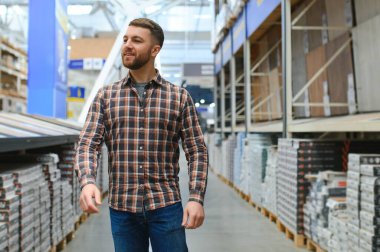 Orta yaşlı bir adam evi için zemin kaplamasını seçiyor..