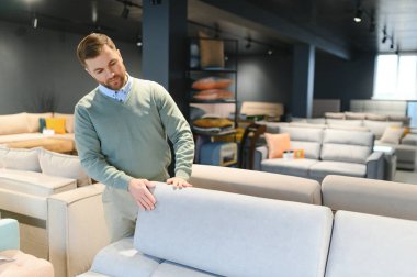 Yakışıklı bir genç mağazadan mobilya seçer..