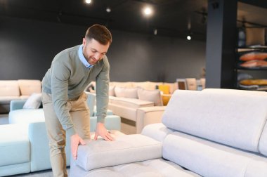 Mobilya dükkanındaki adam kanepeyi seçiyor..