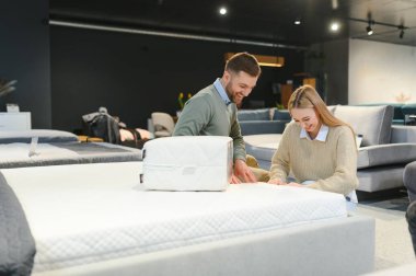 Çift mobilya mağazasında ortopedik yatağı olan yeni bir yatak alıyor..