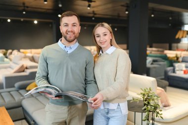 Evli çift mobilya mağazasındaki en iyi yeni kanepeyi seçiyor..