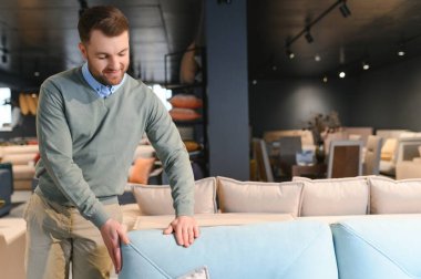 Bir erkek yeni kanepe için kumaş seçer..