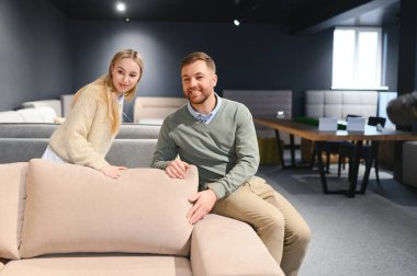 Çift mobilya dükkanında kanepe ve yastık seçiyor..