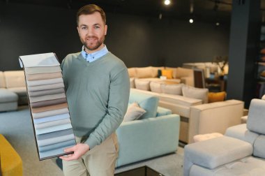 Bir erkek yeni kanepe için kumaş seçer..