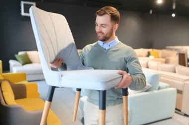 Yakışıklı bir genç mağazadan mobilya seçer..