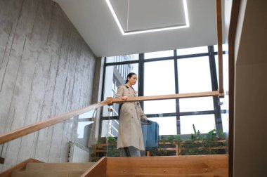 Bavullu güzel bir bayan otelin merdivenlerinden yukarı çıkıyor..