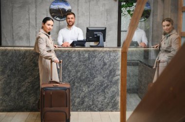 Modern otel lobisinde bagajı olan bir iş kadını..