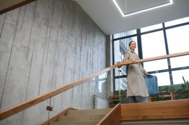 Bavullu güzel bir bayan otelin merdivenlerinden yukarı çıkıyor..