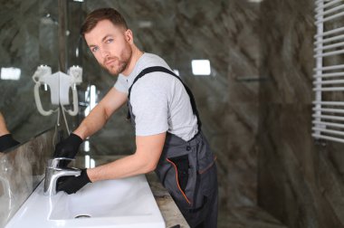 Tesisatçı bir lavabo musluk tamiri.