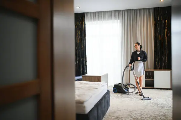 Housekeeper or Maid cleaning hotel room.