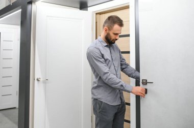 Alıcı mağazadaki kapıyı seçer. Kapıların penceresi. Ev için geniş bir kapı seçimi..